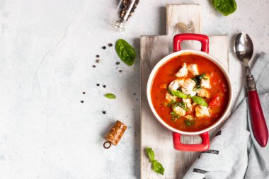 Tavuk, sebze ve fesleğen ile sıcak domates çorbası. Hafif beton arka plan. Uzay kopyalayın. Üstten görünüm. 