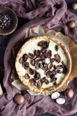 Quiche petrol ve koyu kahverengi beton zemin üzerine peynir ile. Mantar ile tuzlu tart. Uzay baş.