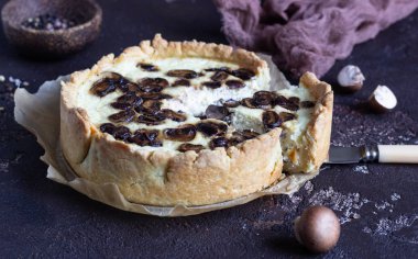 Quiche petrol ve koyu kahverengi beton zemin üzerine peynir ile. Mantar ile tuzlu tart. Uzay baş.