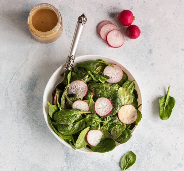 Spenat Och Rädisor Sallad Med Jordnötssmör Dressing Ljus Grå Betong — Stockfoto