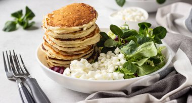 Peynirli tuzlu kek yeşil salata karışımı ve taze çiftlik süzme peynir ile görev yaptı. Sağlıklı kahvaltı ve öğle yemeği. Hafif beton arka plan. Kopya alanı.