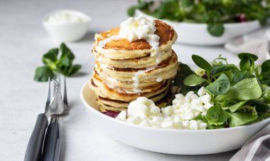 Peynirli tuzlu kek yeşil salata karışımı ve taze çiftlik süzme peynir ile görev yaptı. Sağlıklı kahvaltı ve öğle yemeği. Hafif beton arka plan. Kopya alanı.
