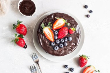 Peynirli kuru üzüm ile dekore edilmiş çikolata sır ve taze çilek ve yaban mersini.