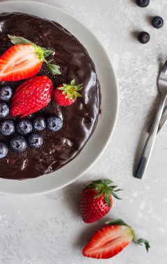 Peynirli kuru üzüm ile dekore edilmiş çikolata sır ve taze çilek ve yaban mersini.