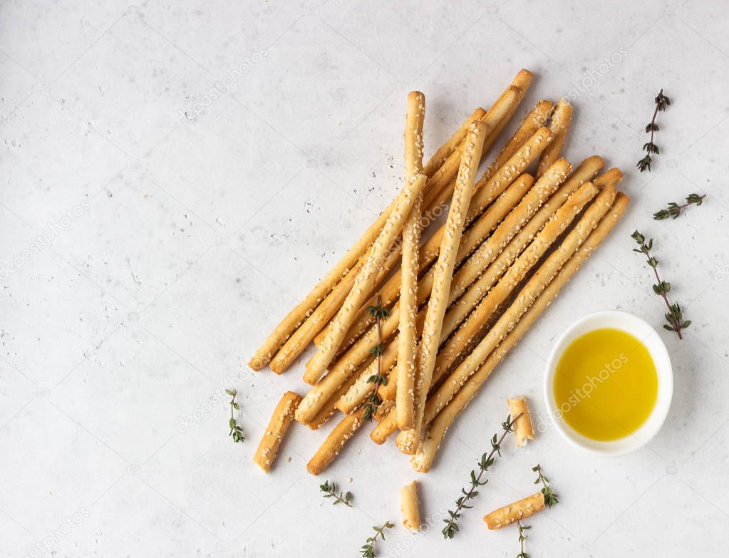 Italian grissini or salted bread sticks on a light stone background. Fresh italian snack. Copy space. 