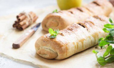 Kuru üzüm ve gri beton zemin üzerine tarçın ile geleneksel elma strudel. Kopya alanı.