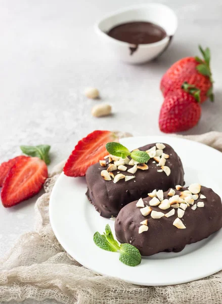 Glazed cheese curds with chocolate, peanut, strawberry and mint on a white plate. Sweet breakfast or dessert. High key.