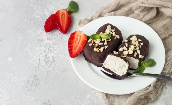 Glazed cheese curds with chocolate, peanut, strawberry and mint on a white plate. Sweet breakfast or dessert. High key.