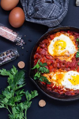 Bir dökme demir tava maydanoz ve ekmek ile domates sosu kızarmış yumurta. Shakshuka, tipik Israil yemeği. Kahvaltı veya öğle yemeği. 