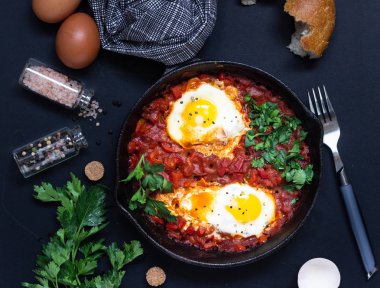 Bir dökme demir tava maydanoz ve ekmek ile domates sosu kızarmış yumurta. Shakshuka, tipik Israil yemeği. Kahvaltı veya öğle yemeği. 