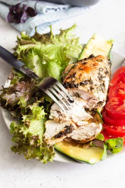 Yeşil salata, domates ve ızgara kabak ile bir tabakta otlar ve zeytinyağı ile tavuk göğsü (fileto) pişirme.