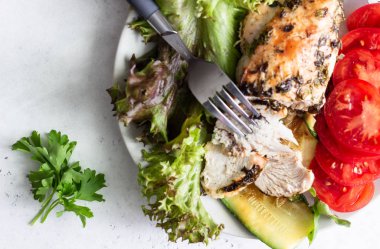 Yeşil salata, domates ve ızgara kabak ile bir tabakta otlar ve zeytinyağı ile tavuk göğsü (fileto) pişirme.