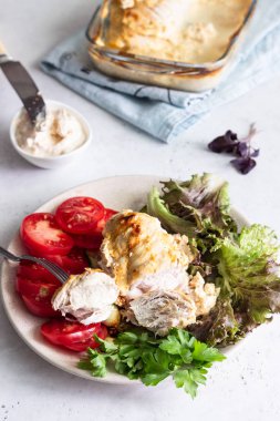 Yeşil salata, domates ve ızgara kabak ile bir tabaktabakta krem peynir sosu ile tavuk göğsü (fileto) pişirme.