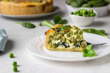 Ispanak ve yeşil bezelye quiche, tart veya pasta pişirme için taze malzemelerle. Açık gri arka plan, kopyalama alanı. 