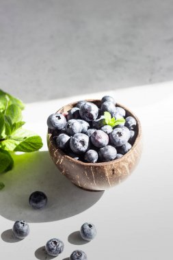 Açık gri taş masadaki ahşap yaban mersini kasesi. Sağlıklı organik mevsimlik meyve arka planı. 