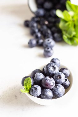 Beyaz seramik bir kapta taze toplayın yaban mersini. Seçici odaklama, metin için kopya alanı. 