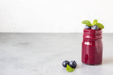Cam kavanoztaze çilek ve nane ile Lezzetli yaban mersini yüzlü. Yaz sağlıklı içecek. Gri taş arka plan. Kopyalama alanı.