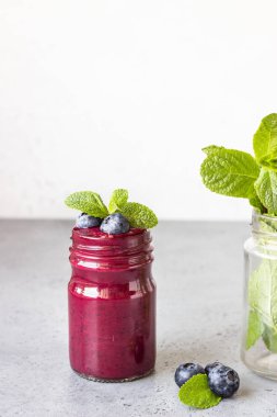 Cam kavanoztaze çilek ve nane ile Lezzetli yaban mersini yüzlü. Yaz sağlıklı içecek. Gri taş arka plan. Kopyalama alanı.