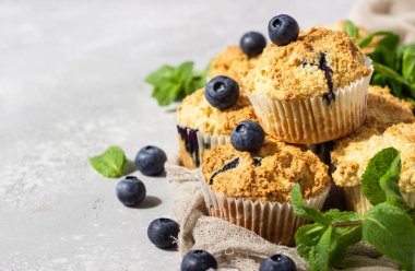 Açık gri taş arka plan taze çilek ve nane yaprakları ile yaban mersini kekler. Kopyalama alanı.