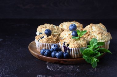 Taze çilek ve nane yaprakları ile blueberry kekler koyu kahverengi taş arka plan üzerinde. Kopyalama alanı.