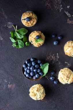 Taze çilek ve nane yaprakları ile blueberry kekler koyu kahverengi taş arka plan üzerinde. Kopyalama alanı.