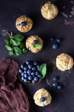 Taze çilek ve nane yaprakları ile blueberry kekler koyu kahverengi taş arka plan üzerinde. Kopyalama alanı.