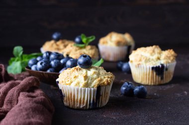 Taze çilek ve nane yaprakları ile blueberry kekler koyu kahverengi taş arka plan üzerinde. Kopyalama alanı.