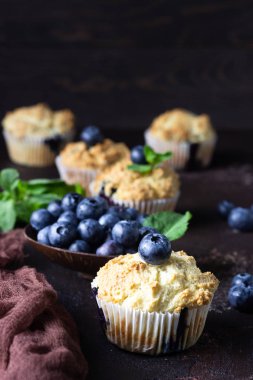 Taze çilek ve nane yaprakları ile blueberry kekler koyu kahverengi taş arka plan üzerinde. Kopyalama alanı.