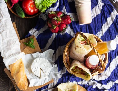 Taze tortilla kavrulmuş tavuk ve sebze, taze meyve suları, çeşitli sebze ve çilek, taze baget ve peynir ile sarar. Piknik için fikirler.