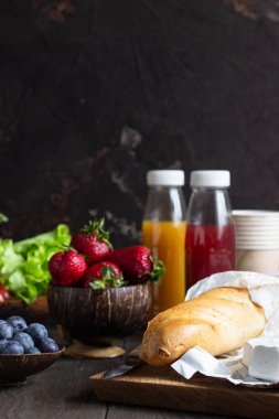 Taze meyve suları, çeşitli sebze ve çilek, taze baget ve peynir. Piknik veya yaz kahvaltısı için fikirler, öğle yemeği.