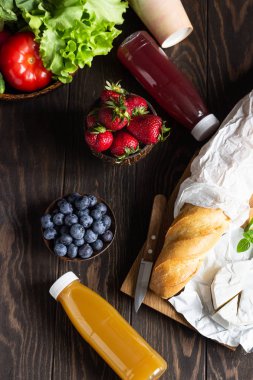 Taze meyve suları, çeşitli sebze ve çilek, taze baget ve peynir. Piknik veya yaz kahvaltısı için fikirler, öğle yemeği.