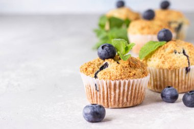 Açık gri taş arka plan taze çilek ve nane yaprakları ile yaban mersini kekler. Kopyalama alanı.