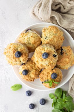 Açık gri taş arka plan taze çilek ve nane yaprakları ile yaban mersini kekler. Kopyalama alanı.