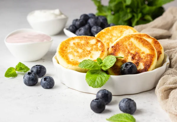小屋奶酪碎石 Syrniki 与新鲜的蓝莓 薄荷和酱汁 浅灰色背景 健康的早餐或饮食午餐 复制空间 — 图库照片