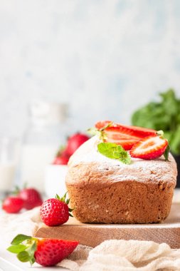 Ahşap tahta üzerinde çilek ve nane ile Pound veya somun kek. Lezzetli yaz tatlısı.