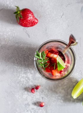 Çilek limonata (çilek, nar, biberiye ve kireç) açık gri arka plan için Malzemeler. Kopya alanı. Üst görünüm, dikey kompozisyon.
