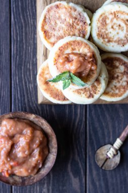 Süzme peynirkrep veya reçel ve nane ile börek. Geleneksel Ukrayna ve Rus mutfağı. Syrniki, ne oldu? Sağlıklı ve diyet kahvaltı.