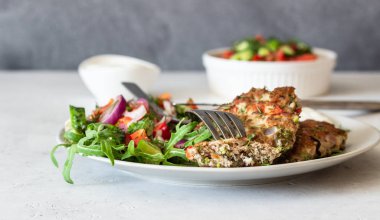 Bir tabaktabaktabak sebze ve sos ile tavuk veya hindi pirzola. Salata ile lezzetli pirzola. Seçici odaklama.