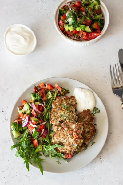 Chicken or turkey cutlets with vegetables and sauce on a plate. Delicious cutlets with salad. Selective focus.