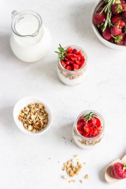 Yunan yoğurt, taze çilek ve kavanozgranola ile Berry yoğurt. Cam bardaksağlıklı kahvaltı parfait. Metin için alan kopyalama.