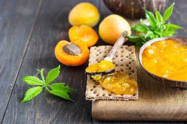 Ahşap bir kapta kayısı reçeli ve ahşap bir arka plan üzerinde taze kayısı. Kopya alanı. Yaz hasat konsepti.