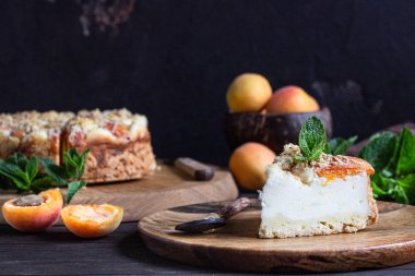 Kayısı ve ufalanmış cheesecake, taze kayısı ve nane. Ahşap arka plan, rustik tarzı. Kopyalama alanı.