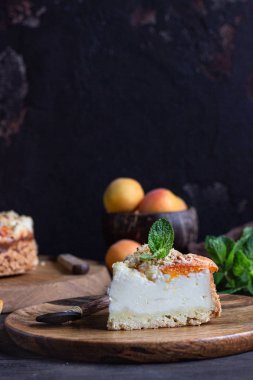 Kayısı ve ufalanmış cheesecake, taze kayısı ve nane. Ahşap arka plan, rustik tarzı. Kopyalama alanı.