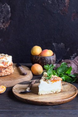 Kayısı ve ufalanmış cheesecake, taze kayısı ve nane. Ahşap arka plan, rustik tarzı. Kopyalama alanı.