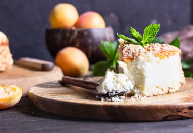 Kayısı ve ufalanmış cheesecake, taze kayısı ve nane. Ahşap arka plan, rustik tarzı. Kopyalama alanı.