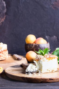 Kayısı ve ufalanmış cheesecake, taze kayısı ve nane. Ahşap arka plan, rustik tarzı. Kopyalama alanı.