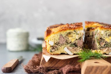 Ahşap bir kesme tahtası üzerinde karaciğer, yumurta ve dereotu doldurma ile pasta. Sağlıklı beslenme öğle veya akşam yemeği.