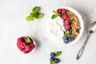Doğal yunan yoğurt, ev yapımı granola ve taze çilek (yaban mersini ve ahududu). 