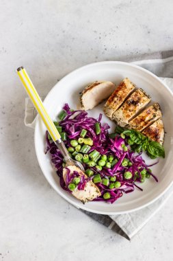 Izgara tavuk, kırmızı lahana, yeşil bezelye ve fasulye ışık arka plan üzerinde. Lezzetli dengeli gıda konsepti. Sağlıklı öğle veya akşam yemeği salatası.