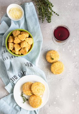 Beyaz seramik tabakta peynir ve kekik ile tuzlu çörekler veya kurabiyeler. Açık gri beton arka plan. 